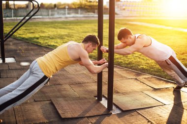 Gün batımı arka plan ile stadyum standında iki adam