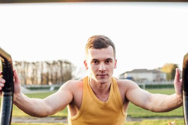 Adam stadyum bölgesinde güneş arka plan ile egzersiz yapmak