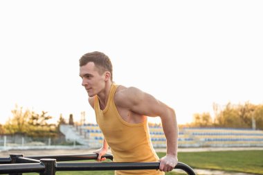 Adam stadyum bölgesinde güneş arka plan ile egzersiz yapmak