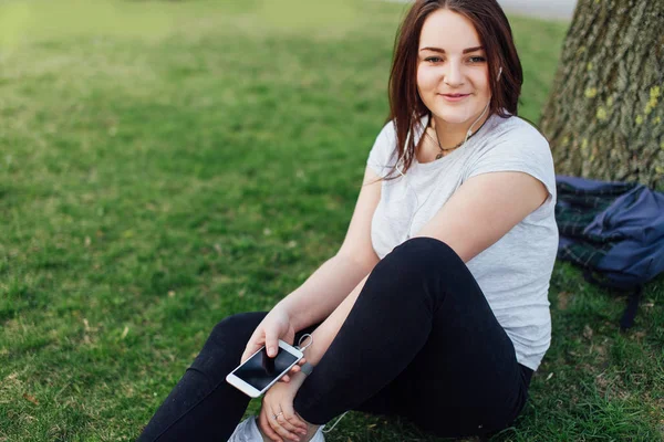 Chica tumbada en un parque y relajarse con fondo verde — Foto de Stock