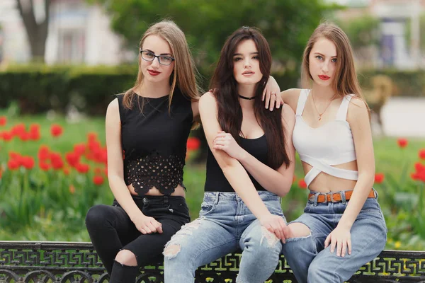 Three girls sit on the park background — Stock Photo, Image