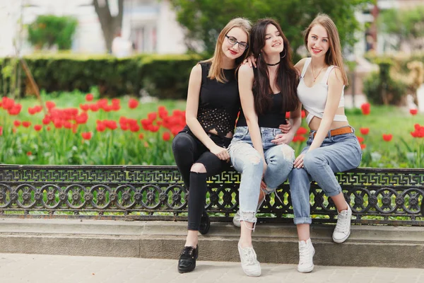 Three girls sit on the park background — Stock Photo, Image