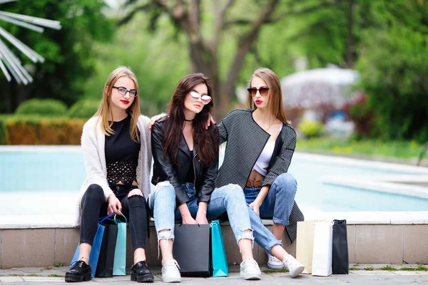 Drie meisjes met boodschappentassen op park — Stockfoto