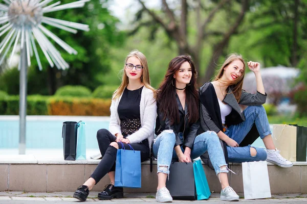 Drie meisjes met boodschappentassen op park — Stockfoto