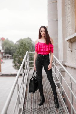 Bir kız poz fotoğraf duvarın yanında