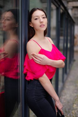 Bir kız poz fotoğraf duvarın yanında