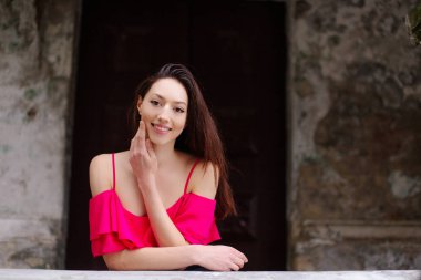 Bir kız poz fotoğraf duvarın yanında