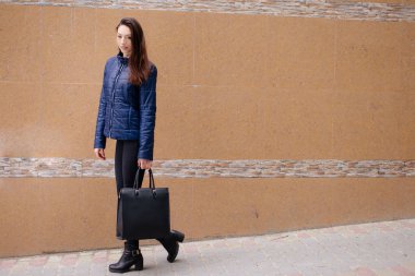 Bir kız poz fotoğraf duvarın yanında