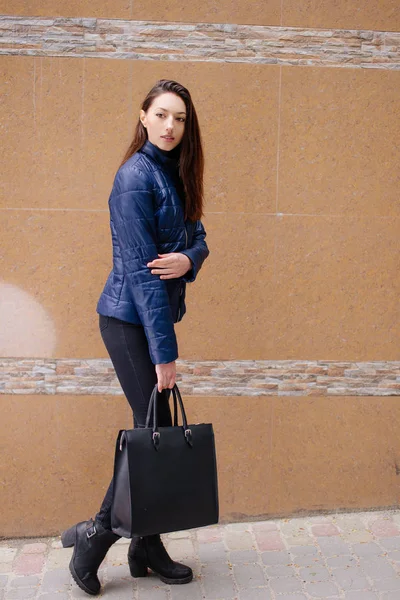 Une fille pose à la caméra près du mur — Photo