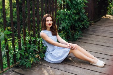 Kız elbisesi ile park arka plan, kamera için poz