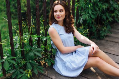 Kız elbisesi ile park arka plan, kamera için poz