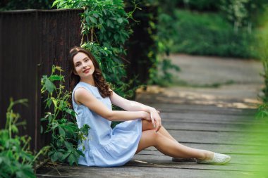 Kız elbisesi ile park arka plan, kamera için poz