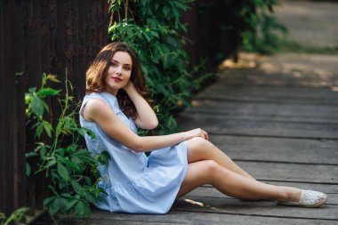 Kız elbisesi ile park arka plan, kamera için poz