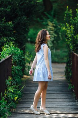 Kız elbisesi ile park arka plan, kamera için poz