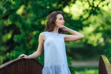 Kız elbisesi ile park arka plan, kamera için poz