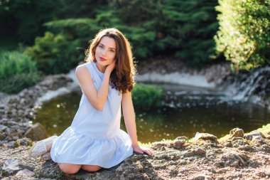 Güzel kız poz güneş ışığı arka plan ile Park'ta kamera için