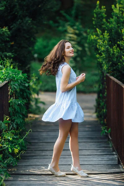Chica pose a cámara en el parque de fondo con su vestido — Foto de Stock