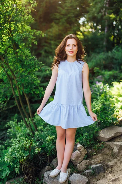 Chica pose a cámara en el parque de fondo con su vestido — Foto de Stock