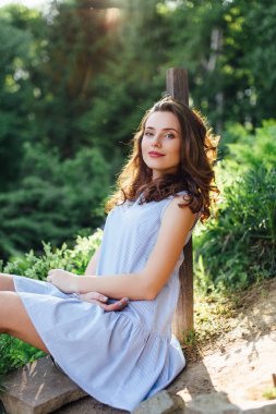 Kız elbisesi ile park arka plan, kamera için poz