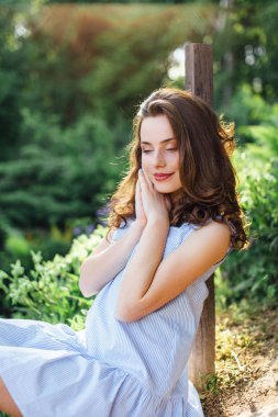 Kız elbisesi ile park arka plan, kamera için poz