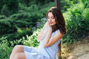 Kız elbisesi ile park arka plan, kamera için poz