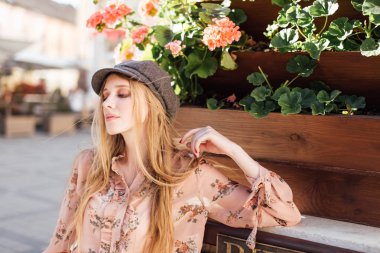 Genç model sokakta stand ve ekmek tutun 