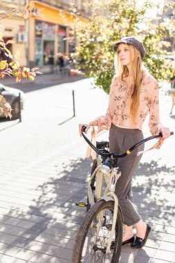 Genç model sokakta stand ve ekmek bisiklet ile tutun