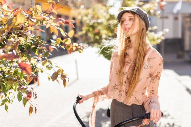 Genç model sokakta stand ve ekmek bisiklet ile tutun