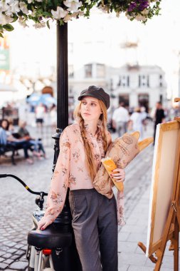 Genç model sokakta stand ve ekmek bisiklet ile tutun