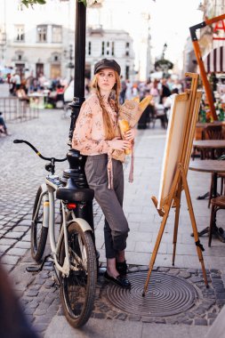 Genç model sokakta stand ve ekmek bisiklet ile tutun
