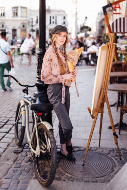 Genç model sokakta stand ve ekmek bisiklet ile tutun
