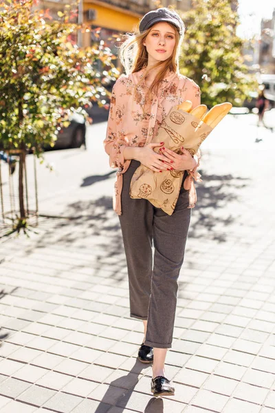 Ung modell stå på gatan och håll bröd — Stockfoto