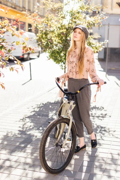 Jovem modelo ficar na rua e segurar pão com bicicleta — Fotografia de Stock