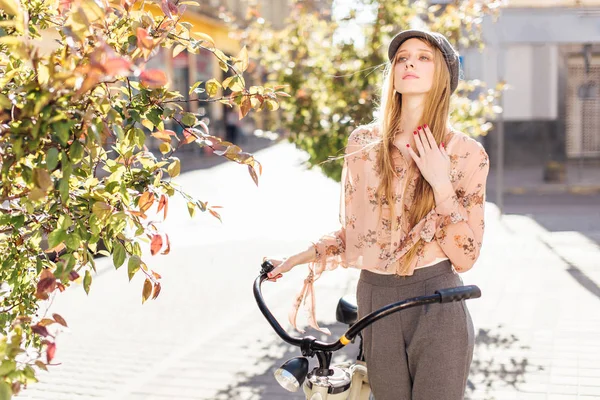 Genç model sokakta stand ve ekmek bisiklet ile tutun