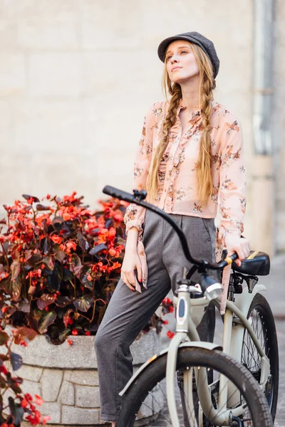 Jovem modelo ficar na rua e segurar pão com bicicleta — Fotografia de Stock