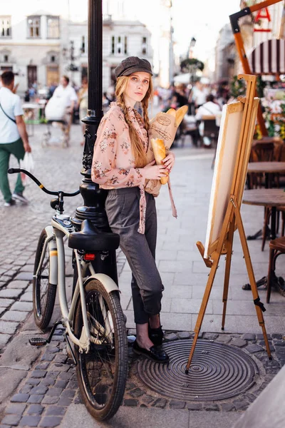 Genç model sokakta stand ve ekmek bisiklet ile tutun
