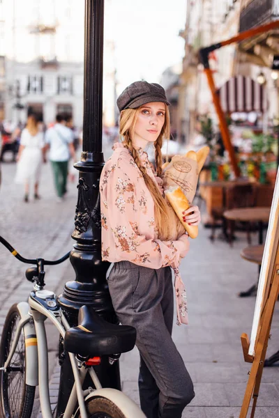 Genç model sokakta stand ve ekmek bisiklet ile tutun
