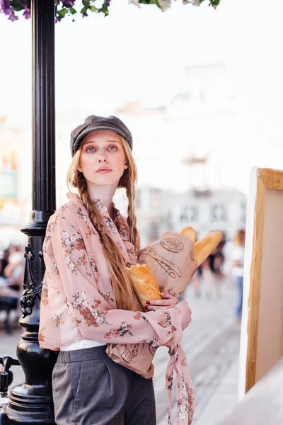 Jeune mannequin debout dans la rue et tenir du pain avec vélo — Photo