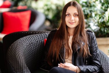 Genç güzel kız kameraya bak ve gülümse, arka plan bulanıklık