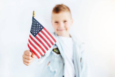 Amerikan bayrağı, kupa ve gülümseme ile küçük çocuk stand