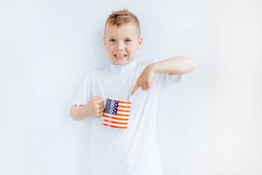 Amerikan bayrağı, kupa ve gülümseme ile küçük çocuk stand