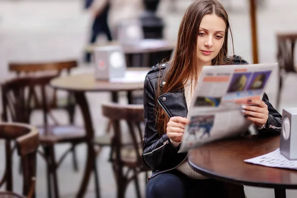 少女がテーブルに座るし、雑誌を読む — ストック写真