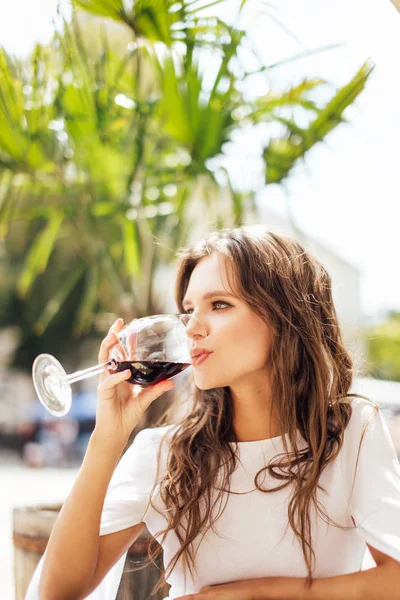 Mädchen trinken ein Glas Wein am Restauranttisch — Stockfoto