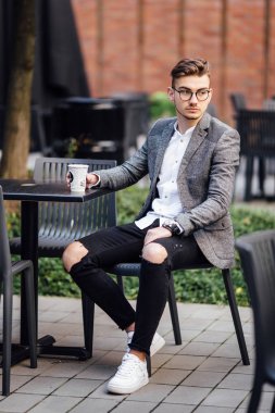 Sandalyede oturan ve onun gözetiminde izlerken bir adam