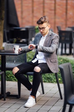 Sandalyede oturan ve onun gözetiminde izlerken bir adam