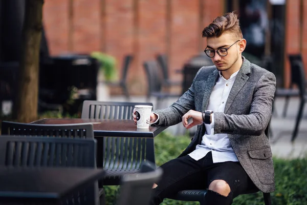 Sandalyede oturan ve onun gözetiminde izlerken bir adam