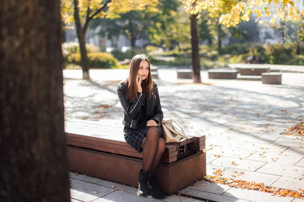 年轻女孩谈电话时公园背景 — 图库照片