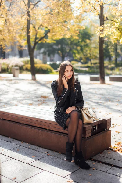 Ung tjej prata i telefon på park bakgrund — Stockfoto
