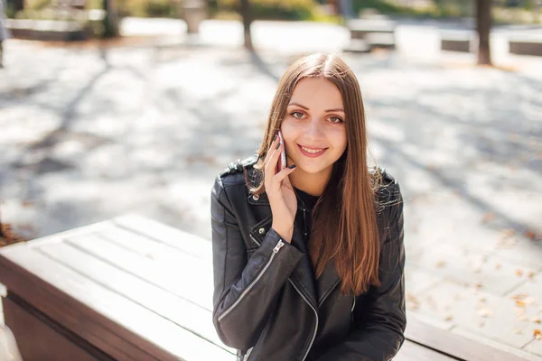 Nuori tyttö puhua puhelimessa puistossa tausta — kuvapankkivalokuva