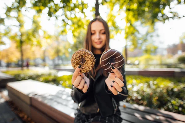 Jong meisje donut eten in park herfst achtergrond — Stockfoto